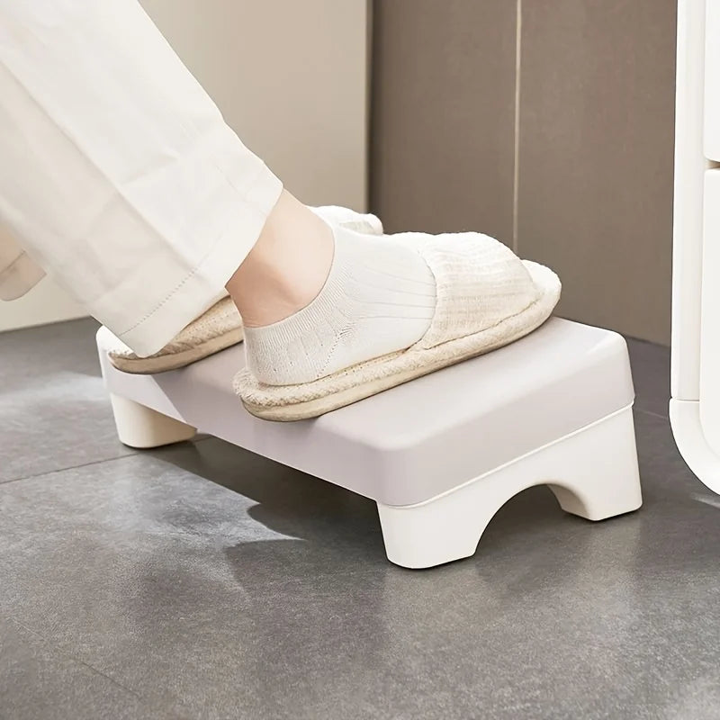 Vue latérale repose-pieds ergonomique blanc avec pantoufles - position idéale pour réduire les tensions lombaires en position assise